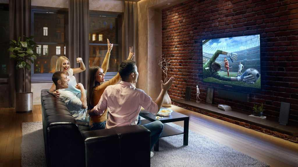Friends cheering a football match at home